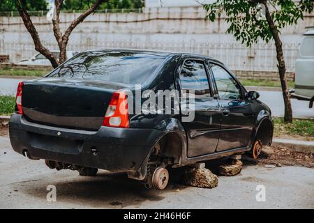 Zaporozhye, Ukraine - Juli 14 2020 : Ein zerbrochener Pkw ohne Räder steht auf Ziegelsteinen Stockfoto