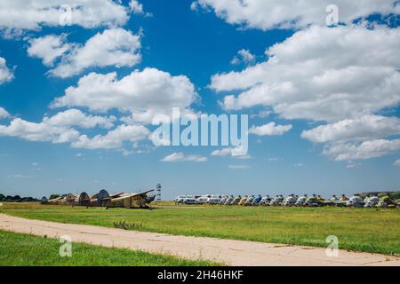 Alte zerstörte verlassene Flugzeuge und Hubschrauber auf dem Feld, Friedhof von alten Hubschraubern und Flugzeugen. Stockfoto