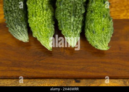 Frisches und grünes bitteres Kürbisgemüse auf einem Holztisch mit Kopierfläche Stockfoto