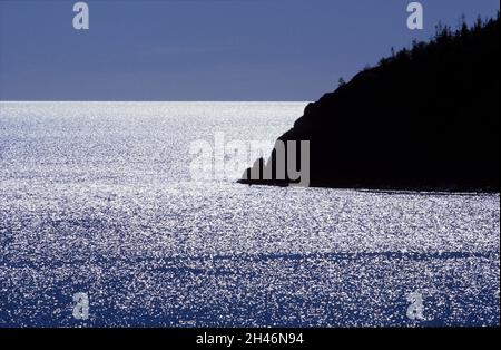 Die Ostsee, Schweden im Jahr 1988, analog. Strahlender Sonnenschein, Gegenlicht von der Ostsee. Insel auf der rechten Seite. Sommer. Stockfoto