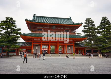 Tourist am Heian Shrine Haupttor oder Oten-mon mit dekorativer großer japanischer weißer Laterne und bewölktem Himmel vor Hintergrund. Stockfoto