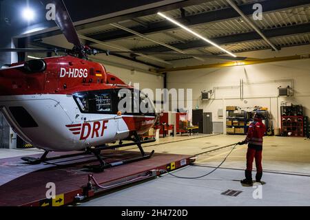 PRODUKTION - 11. Oktober 2021, Baden-Württemberg, Villingen-Schwenningen: Nach der Rückkehr zum Stützpunkt fährt Pilot Roy Fleischer den auf einer Plattform stehenden Rettungshubschrauber in den Hangar. Der Rettungshubschrauber Christoph 54 ist der einzige in Baden-Württemberg, der auch Nachtflugkapazitäten hat. Die Nachtcrew mit den beiden Piloten übernimmt die fliegende Intensivstation von 6.30 Uhr abends bis 7 Uhr am nächsten Morgen. Sie ist auf der Station Villingen-Schwenningen des Deutschen Luftrettungsdienstes (DRF) stationiert und fliegt von dort aus Einsätze im ganzen Land, wenn auch dort Stockfoto