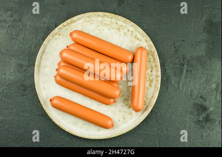 Eine große Marmorplatte mit Rohwürsten auf schwarzem Hintergrund. Draufsicht Stockfoto