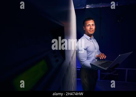 Ruhiger IT-Techniker mit Laptop im Serverraum Stockfoto
