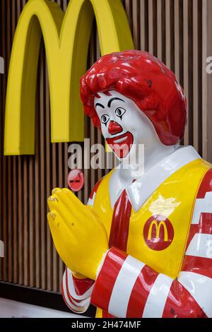 McDonald's Clown vor einer McDonald's-Niederlassung in Bangkok, Thailand, mit gefalteten Händen, die den traditionellen thailändischen Gruß, den „wai“, vorführen Stockfoto