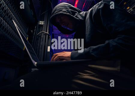 Experte Cyberkriminelle Installation von Malware mit seinem Laptop Stockfoto