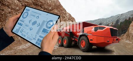 Man steuert autonom Bergbau-LKW mit digitalen Tablet Stockfoto