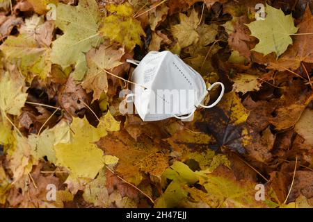 FFP2-Maske im Laub, vierte Corona-Welle im Herbst, Österreich, Europa - FFP2 Maske im Laub, vierte Koronawelle im Herbst, Österreich, Europa Stockfoto