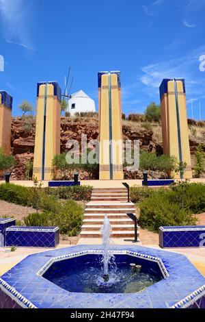 Moderne blaue Fliesen- Brunnen auf dem Hügel mit einem traditionellen Weißen Mühle an der Rückseite, Castro Marim, Algarve, Portugal, Europa. Stockfoto