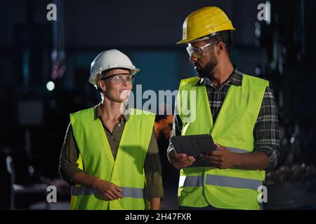 Porträt von Industrieinspektoren, die in Innenräumen in einer Metallwerkstatt eine allgemeine Überprüfung durchführen. Stockfoto