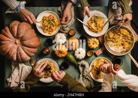 Freunde essen Butternut Squash Pasta mit Wurst und Salbei Stockfoto