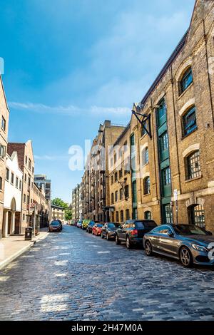 Umgebaute Lagerhäuser und gepflasterte Straße entlang der Wapping Wall, Wapping, London, Großbritannien Stockfoto