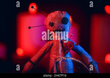 Voodoo Doll mit Nadeln in rot dramatische Beleuchtung Nahaufnahme. Stockfoto