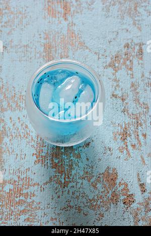 Blaues alkoholfreies Getränk mit Eis in einem Glas mit Basilikumkernen auf blauem Hintergrund. Cocktail. Thailändisch. Stockfoto