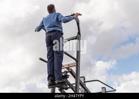 Hübscher junger Mann in einem schwarzen Anzug, weißem Hemd und Krawatten-Training im Fitnessstudio Stockfoto