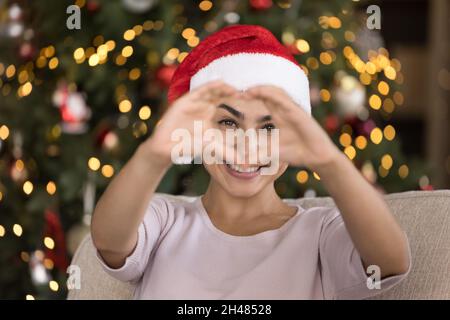 Fröhliche junge indische Frau, die ein Liebessymbol zeigt. Stockfoto