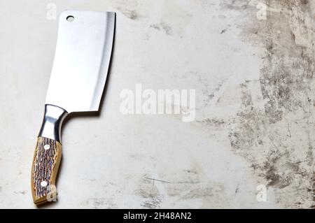Fleischspalter auf Holzhintergrund. Küchenmesser oder Metzgerspalter aus Edelstahl auf einer Holzplatte Stockfoto