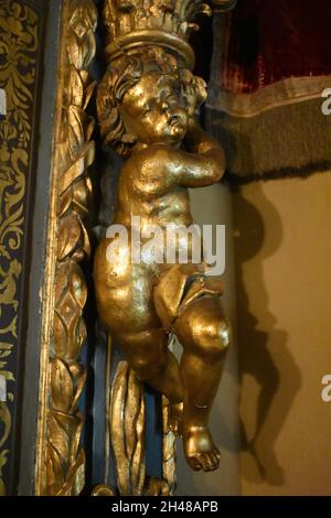 Vertikale Aufnahme einer goldenen geschnitzten Holzfigur in einer Luxusresidenz Stockfoto