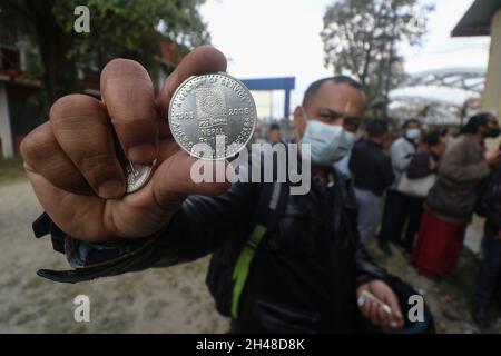 Kathmandu, NE, Nepal. November 2021. Die Menschen zeigen die Silber- und Goldmünzen, nachdem sie von der Nepal Rastra Bank gekauft wurden, die am 1. November 2021 für Dhanteras in Kathmandu, Nepal, eröffnet wurde. Die Nachfrage nach Juwelieren steigt am Tag von Dhantaresh hoch, wenn die Menschen die Juwelen anbeten und die Göttin Laxmi von Wohlstand und Wohlstand beten, um ihr Haus zu betreten. (Bild: © Aryan Dhimal/ZUMA Press Wire) Stockfoto