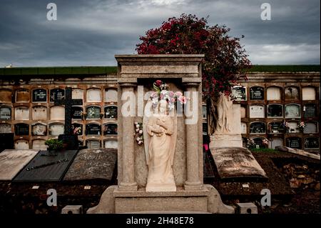 Barcelona, Spanien. 1. November 2021, Barcelona, Spanien: Blumen schmücken eine Skulptur unter den Gräbern des Friedhofs von Poblenou in Barcelona. Der 01. November ist der katholische Feiertag Allerheiligen, der dem Gedenken an die Verstorbenen gewidmet ist. Quelle: Jordi Boixareu/Alamy Live News Stockfoto