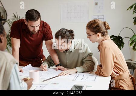 Gruppe kreativer Architekten diskutiert Grundrissprojekt bei Teambesprechung Stockfoto