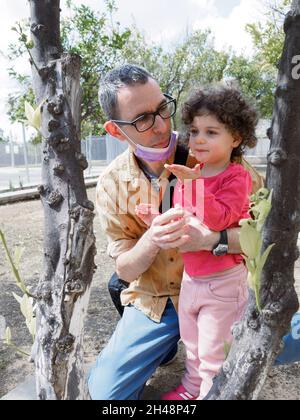 Das junge Kleinkind spielt draußen auf einem Spielplatz mit ihrem Vater. Model Release verfügbar Stockfoto