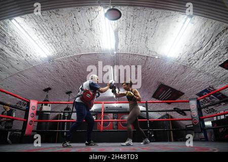 Die britische Profiboxerin Ruqsra Begum, die während einer Trainingseinheit im KO Boxing Gym in Bethnal Green, East London, mit Trainer Steve Walters, spezifische Kombinationen, die sie im Kampf einsetzen wird, Vor ihrem Superflyweight-Kampf gegen Tasha Boyes am Freitag, dem 5. November. Ausgabedatum: Montag, 1. November 2021. Stockfoto