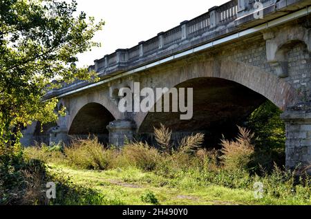 Die Bögen der alten Brücke, die das Bett des Crostolo-Baches in der Nähe der Stadt Puianello in der Provinz Reggio Emilia überblickt Stockfoto