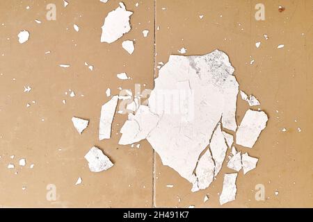 Das Innere ist ein altes Haus, das renoviert werden muss. Der zerbröckelnde weiße Putz von der Wand liegt auf dem Boden, in der Nähe des alten Heizkörpers. Stockfoto