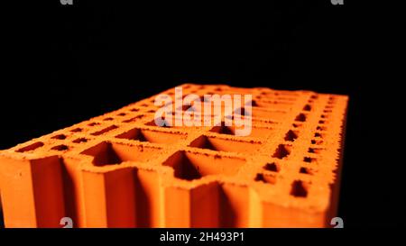 Bau- und Materialkonzept. Abstrakte Animation der orangefarbenen 3d-Ziegeloberfläche auf dem schwarzen Hintergrund. Stockfoto