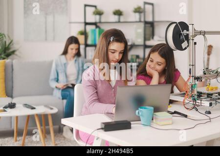 Kinder lernen 3D-Druck zu Hause, sie verwenden einen 3D-Drucker und einen Laptop, Wissenschaft und Bildung Konzept Stockfoto