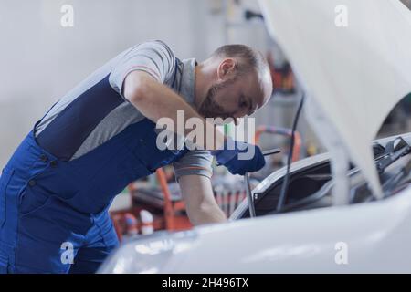 Mechaniker, der einen Automotor in der Autowerkstatt befestigt Stockfoto