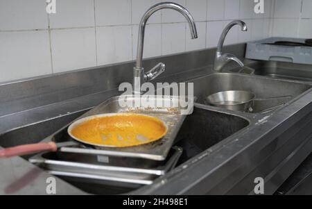 Schmutziges Geschirr zum Waschen an einem Waschbecken im Restaurant aufbewahrt Stockfoto