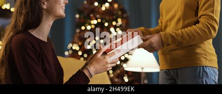 Glückliches Mädchen erhält ein schönes Weihnachtsgeschenk von ihrer Mutter Stockfoto