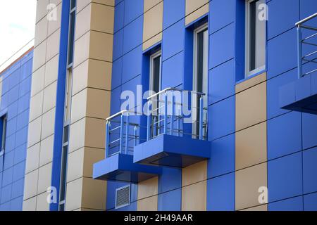 Dekorative Fassade des Hauses. Verkleidung in Grau und Blau für die Wand eines mehrstöckigen Gebäudes. Wand eines Mehrfamilienhauses mit Fenster Stockfoto