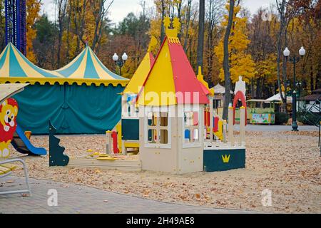 Spielplatz aus Kunststoff-Paneelen in verschiedenen Farben. Haus und Sandkasten auf dem Spielplatz im Herbst. Moderne Spielplätze sind ergonomisch und sicher. Stockfoto