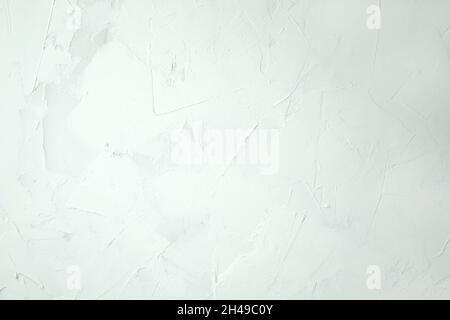 Weißer Kitt-Hintergrund. Weiße abstrakte Textur der Oberfläche mit Kitt bedeckt. Texturierter Hintergrund der Füllstoff-Paste mit Kitt Messer in unregulra aufgetragen Stockfoto