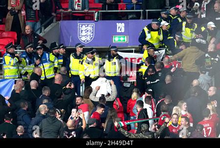 Datei-Foto vom 12-10-2021 von Ungarn Fans stoßen während des FIFA-WM-Qualifikationsspiel im Wembley-Stadion, London, auf Polizeibeamte an den Ständen. Ungarn-Fans werden am 15. November nach Zusammenstößen mit der Polizei während des Spiels gegen England in Wembley im vergangenen Monat die Teilnahme an der Finalweltcup-Qualifikation des Landes nach Polen verwehrt. Ausgabedatum: Montag, 1. November 2021. Stockfoto