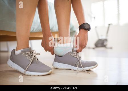 Hände einer asiatischen Frau, die sich für das Training vorbereitet und Schuhe bindet Stockfoto