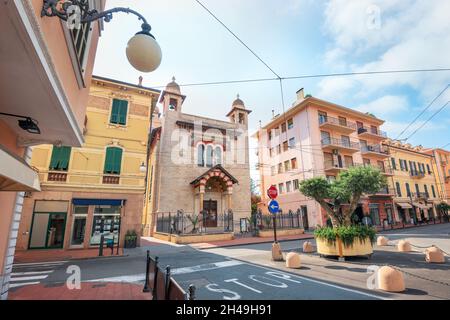 Blick auf die Straße mit der Kirche im Ferienort Bordighera. Imperia, Ligurien, Italien Stockfoto