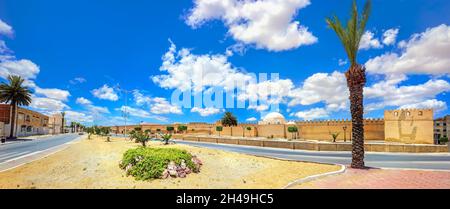 Panoramalandschaft mit Straße und Blick auf die alten Mauern der Großen Moschee in der historischen Stadt Kairouan. Tunesien, Nordafrika Stockfoto