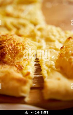 Heißer Khachapuri im imeretischen Stil. Stretching von verarbeitetem Käse. Unglaublich leckeres Gericht. Stockfoto