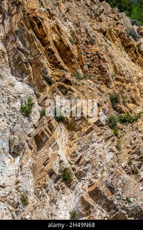 Eine Nahaufnahme mit Details der Risse, Spalten und Farbvariationen an der Seite eines felsigen Berghangs in Colorado. Stockfoto