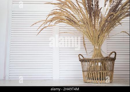 Nahaufnahme von getrockneten Blumen. Trockene Stacheletts und Kräuter in einem Weidenkorb austrocknen. Minimalistisch und gemütlich eingerichtet. Stockfoto