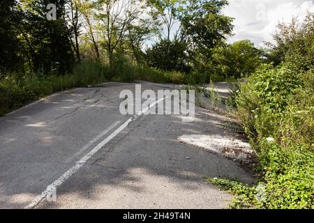 Geschwollener Asphalt. Die zerstörten Folgen der Straße des natürlichen Kataklysmus des Erdrutsches des Bodens. Asphalt durch Erdrutsch verschoben. Stockfoto