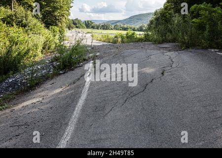 Geschwollener Asphalt. Die zerstörten Folgen der Straße des natürlichen Kataklysmus des Erdrutsches des Bodens. Asphalt durch Erdrutsch verschoben. Stockfoto