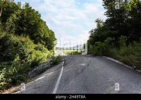 Geschwollener Asphalt. Die zerstörten Folgen der Straße des natürlichen Kataklysmus des Erdrutsches des Bodens. Asphalt durch Erdrutsch verschoben. Stockfoto