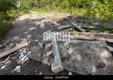 Geschwollener Asphalt. Die zerstörten Folgen der Straße des natürlichen Kataklysmus des Erdrutsches des Bodens. Asphalt durch Erdrutsch verschoben. Stockfoto