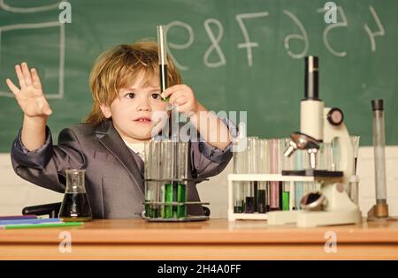 Lernen Sie für die Zukunft. Biologie Wissenschaft. Teströhrchen mit Flüssigkeit für die Forschung. Kleiner Junge verwenden Mikroskop am Unterricht. Ergebnis. Medizinisch. Kleines geniales Kind Stockfoto