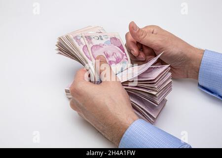 Mann zählt türkisches Geld mit seiner Hand. Türkische Lira-Banknoten. Stockfoto